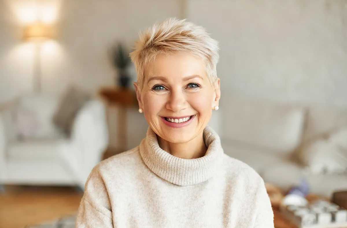 Mature woman smiling after dental implant treatment