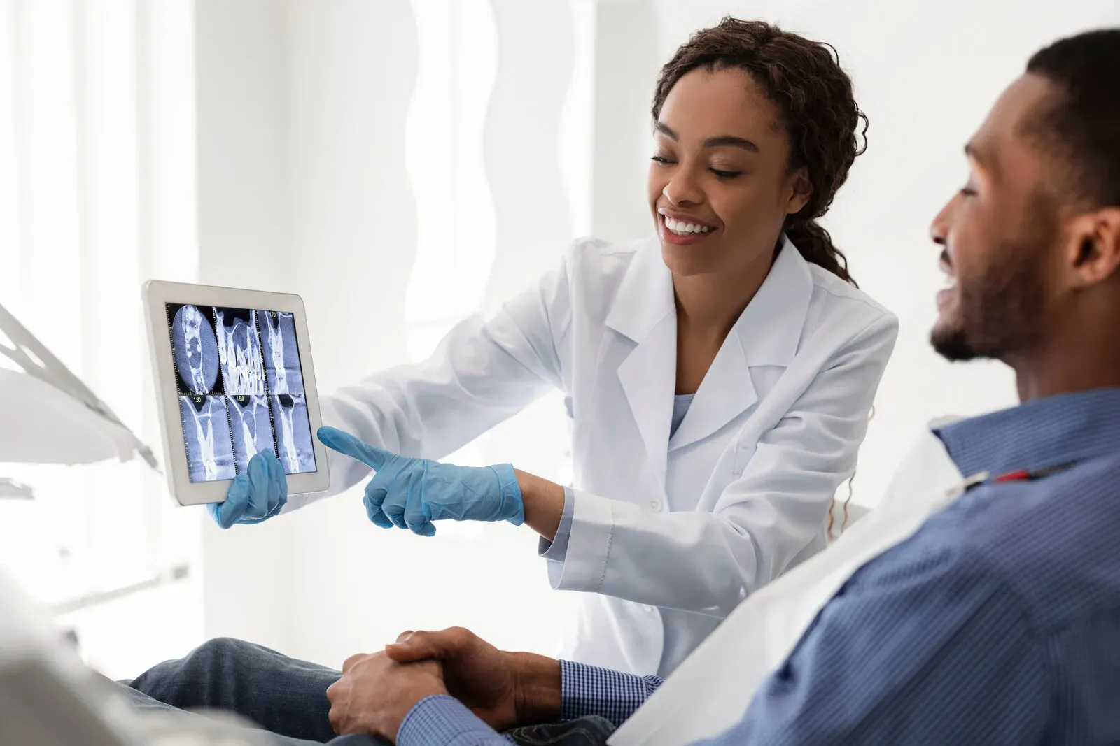 Dentist showing patient their dental x-ray on tablet