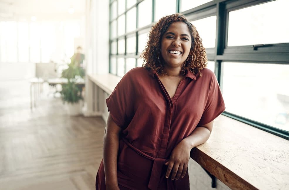 Woman leaning on counter near window