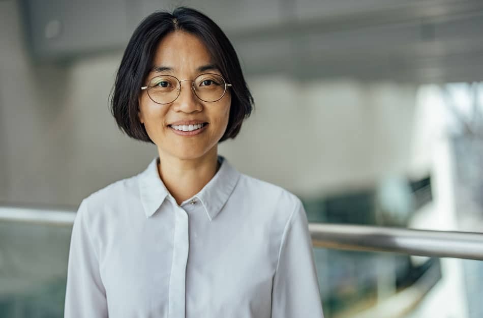 Woman in white shirt and glasses smiling